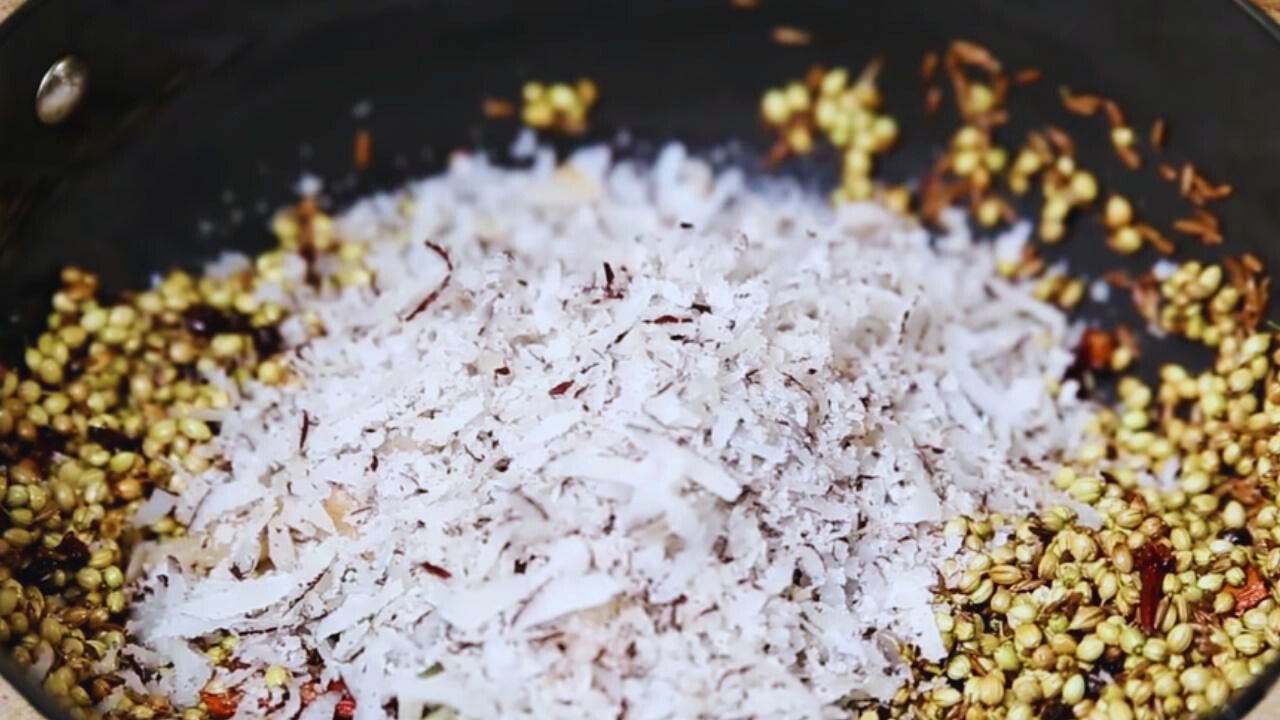 Adding ½ cup of dry coconut to the wok