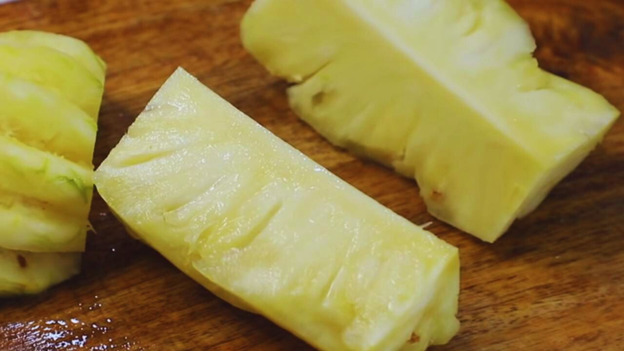 Cutting the pineapple into four pieces