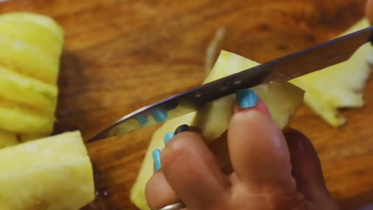 Cutting away the juicy flesh of the pineapple from the hard part