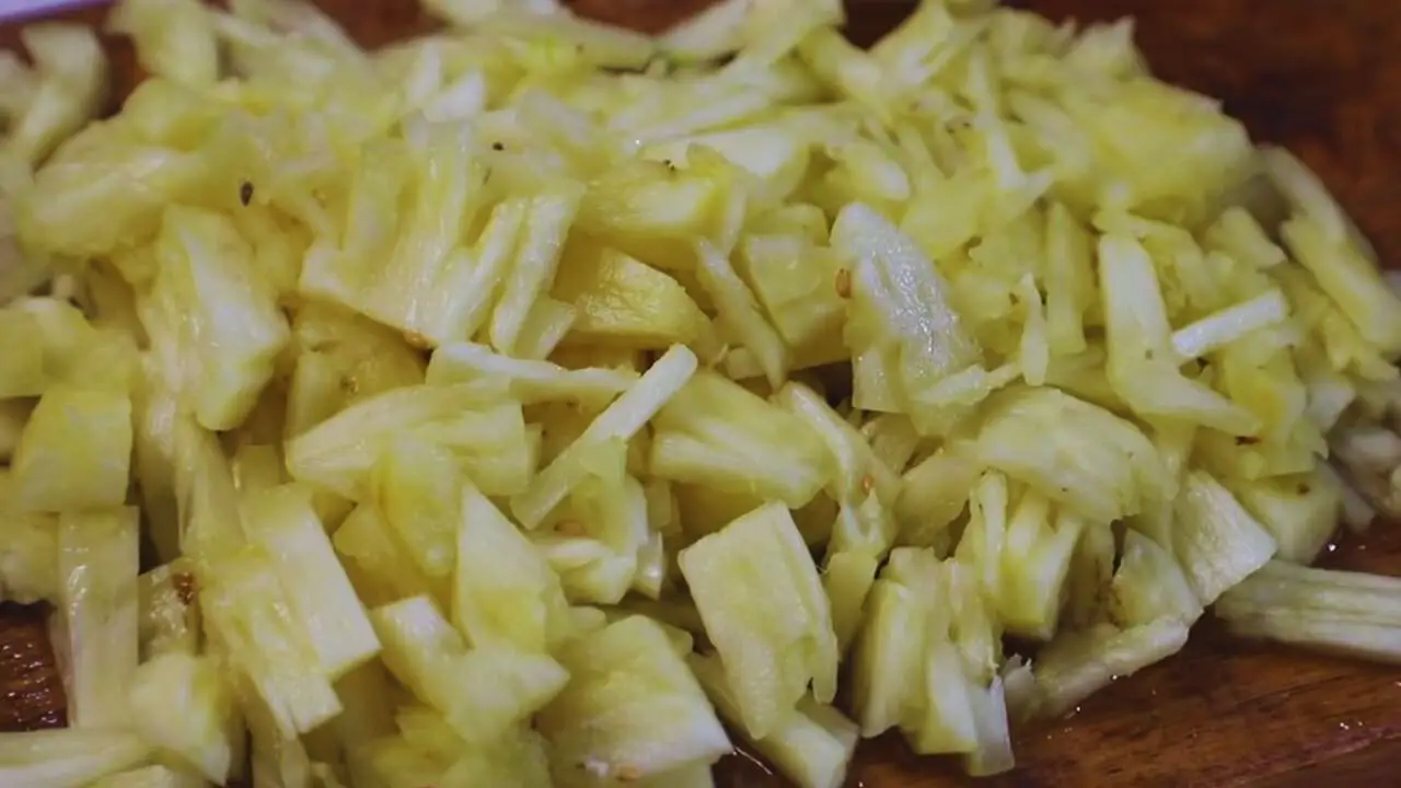 Chopping the pineapple into smaller and finer pieces