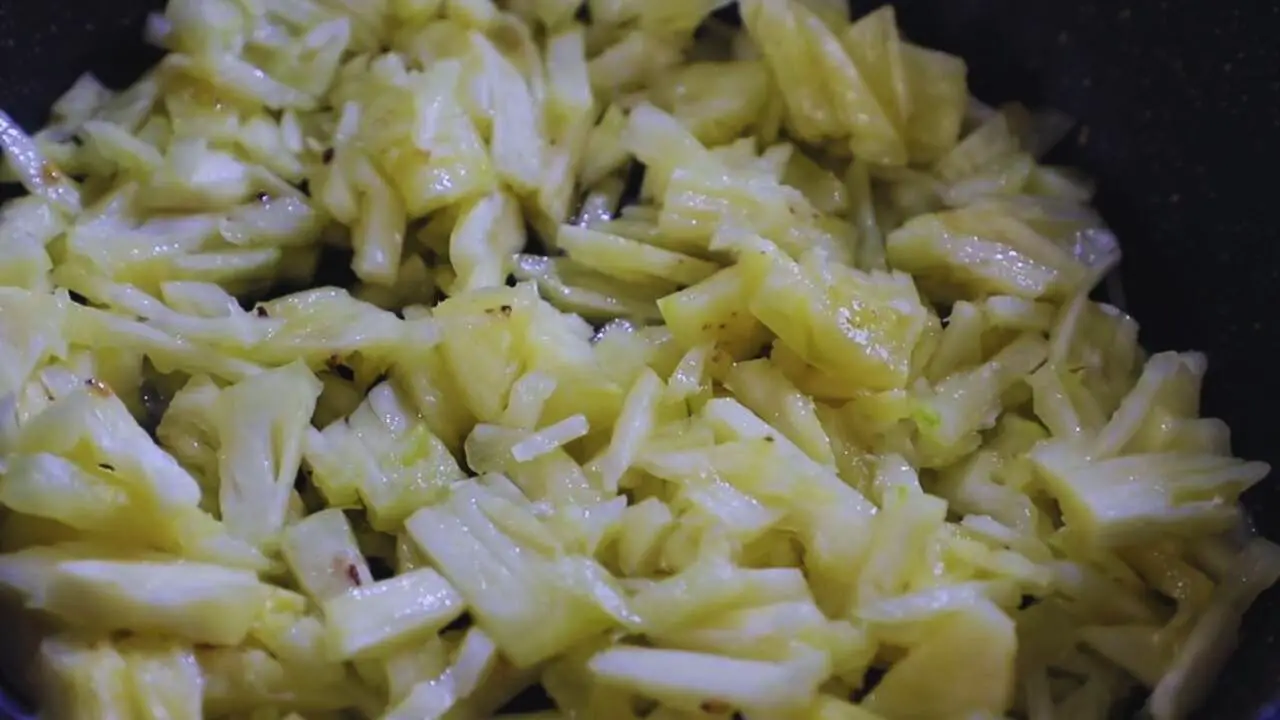 Chopped pineapple pieces in wok