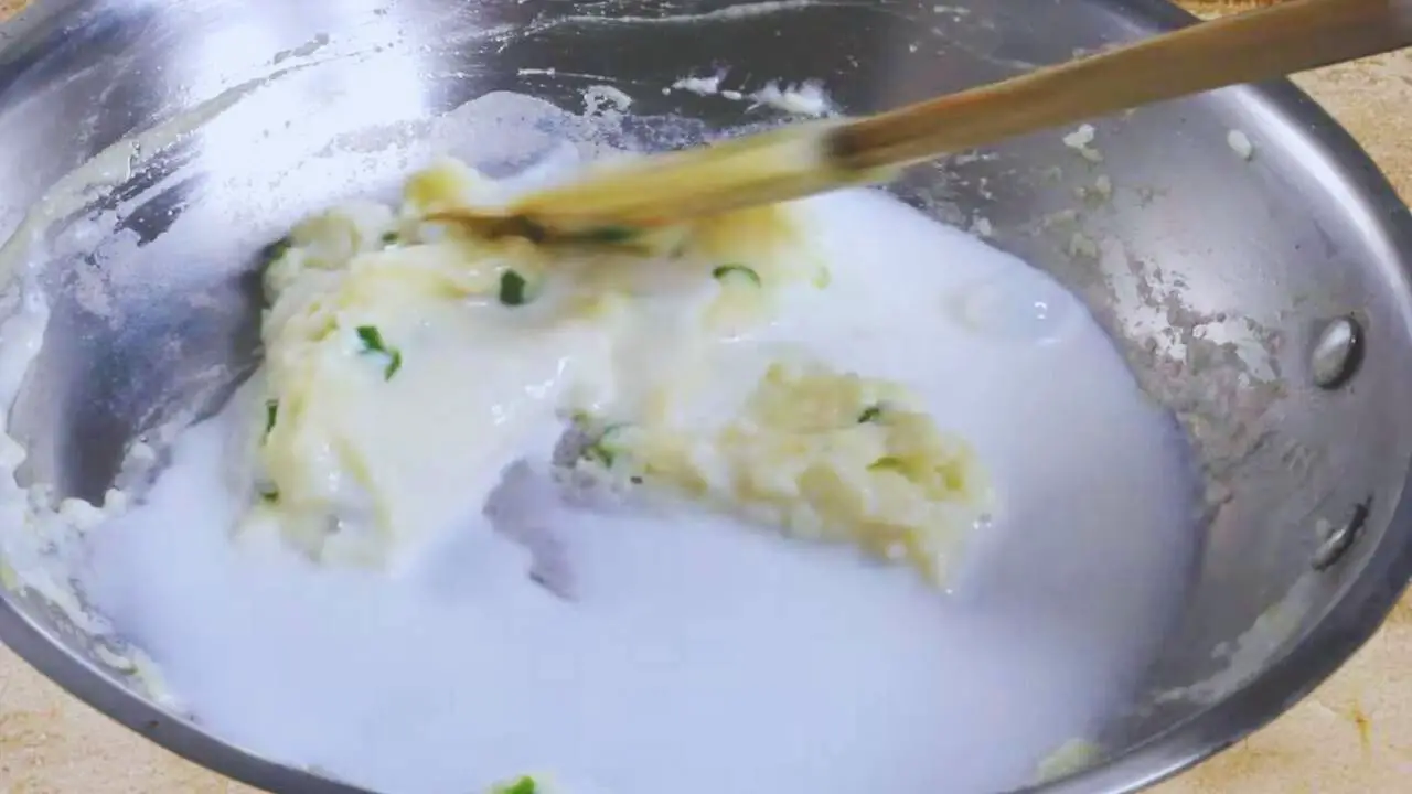 Adding milk to the roux to make the chicken finger mixture 