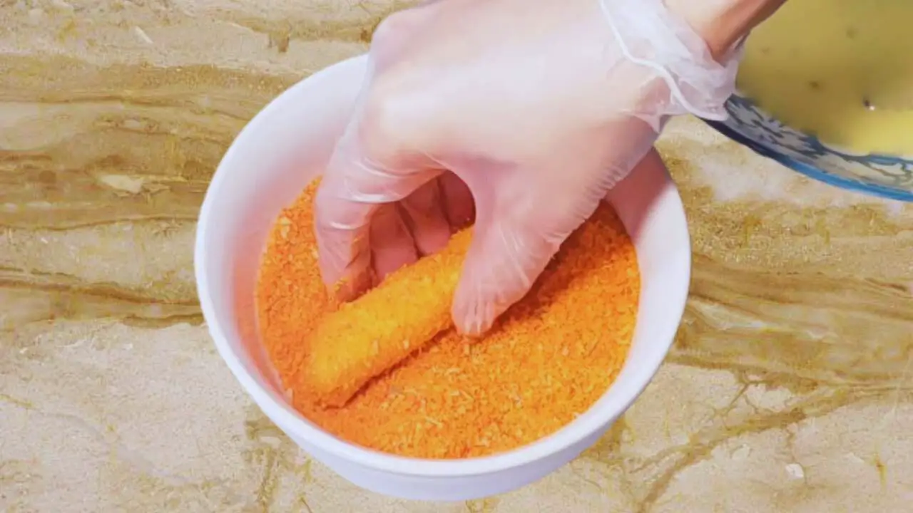 Coating cheese stick with bread crumbs