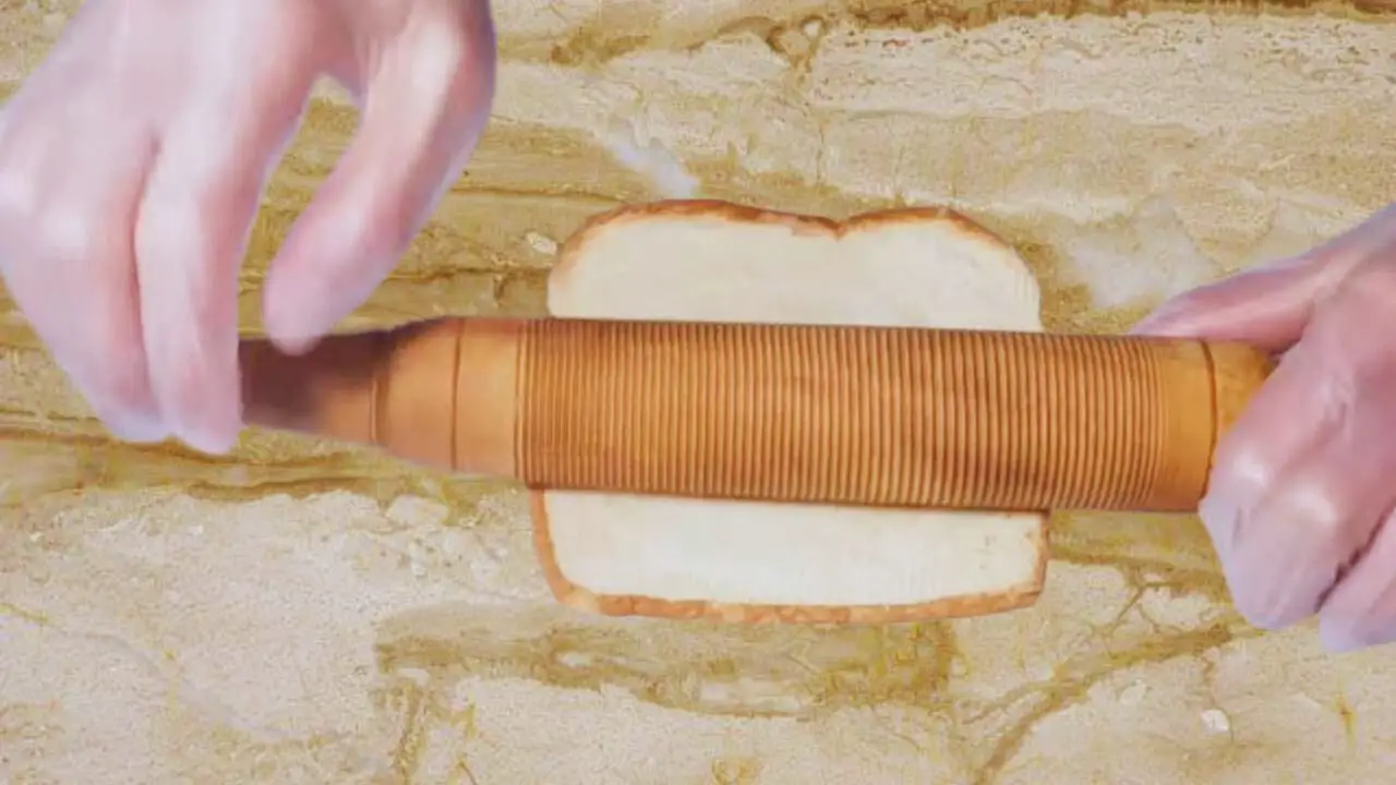 Flattening bread slices to make cheese sticks 