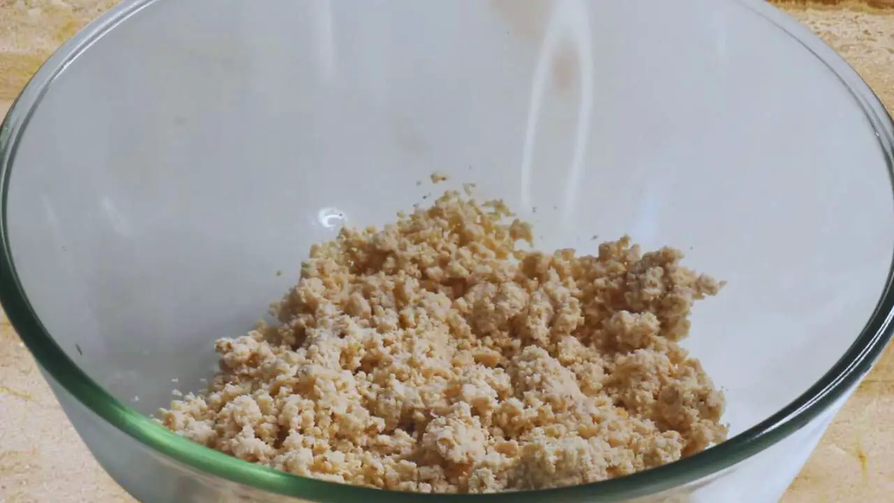 Transferring the ground chicken and bread to a bowl to make chicken fingers 