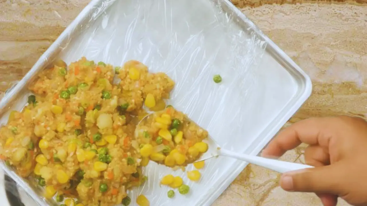 Transferring vegetable finger mixture to a tray