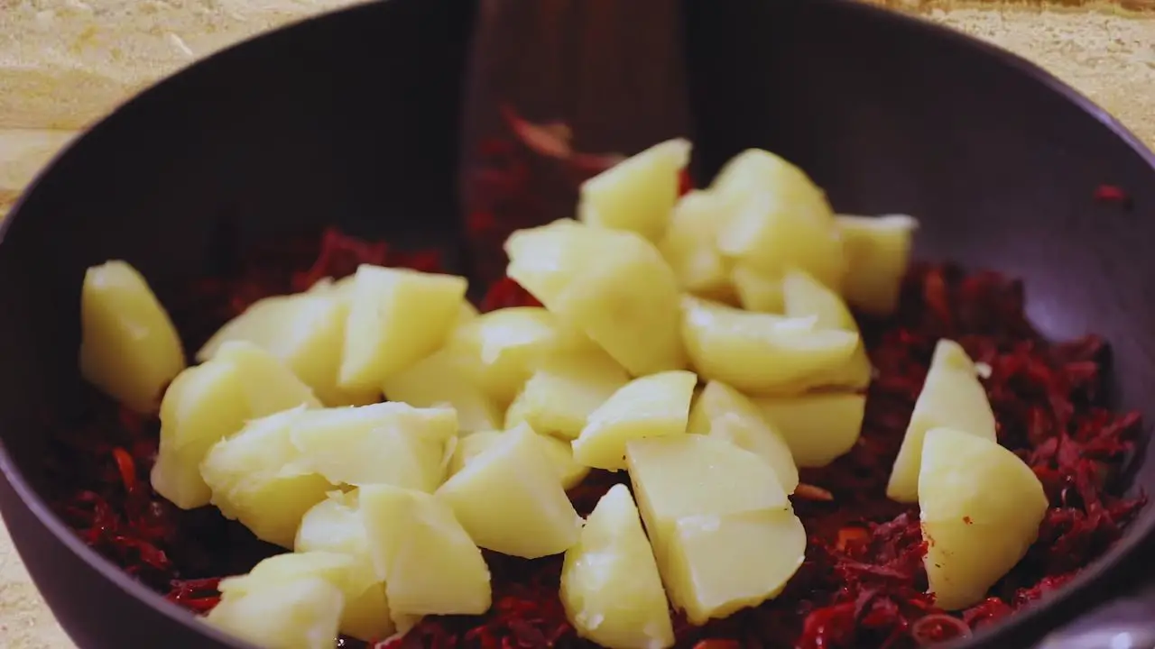 Adding boiled potatoes to the beetroot cutlet mixture 