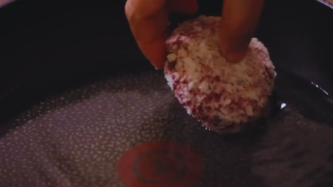 Putting beetroot cutlets in hot oil 