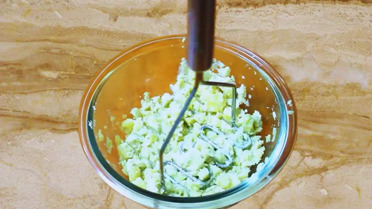 Mashing sweet potato for easy shaping of the tikkis