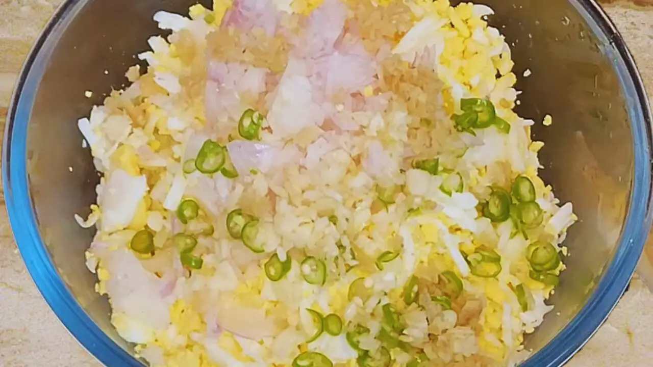 Adding chilies, onions, and ginger to Egg Cutlet mixture 