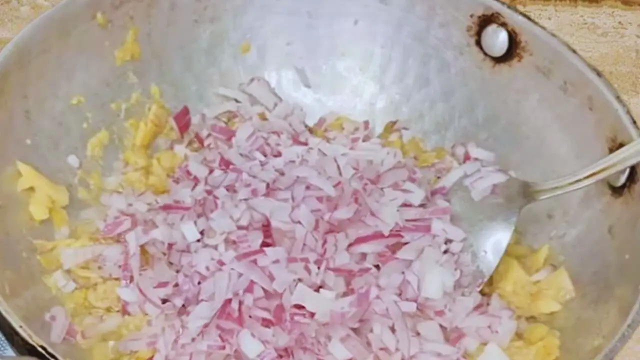 Adding chopped onions to fish to make momo