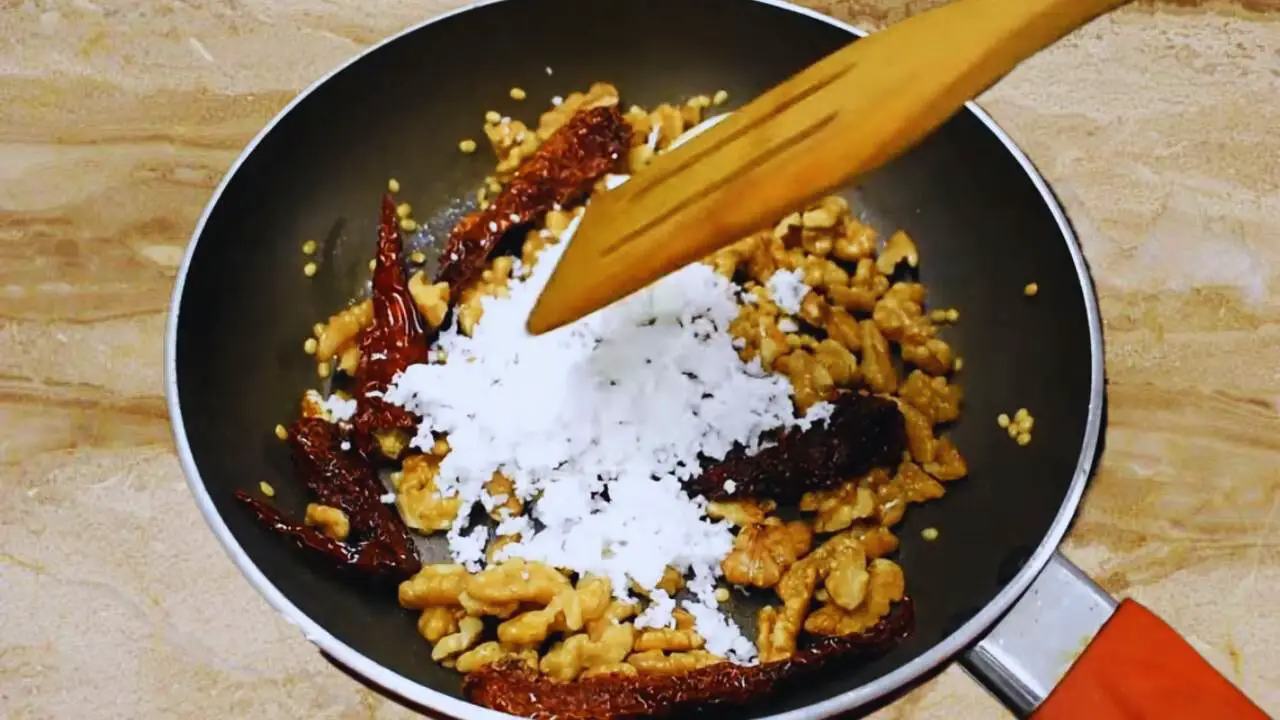 Adding coconut to the Walnut Chutney ingredients 