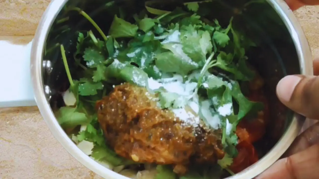 Tomato green chili chutney recipe step 9 Adding coriander leaves and tamarind to the Tomato Green Chili Chutney ongredients