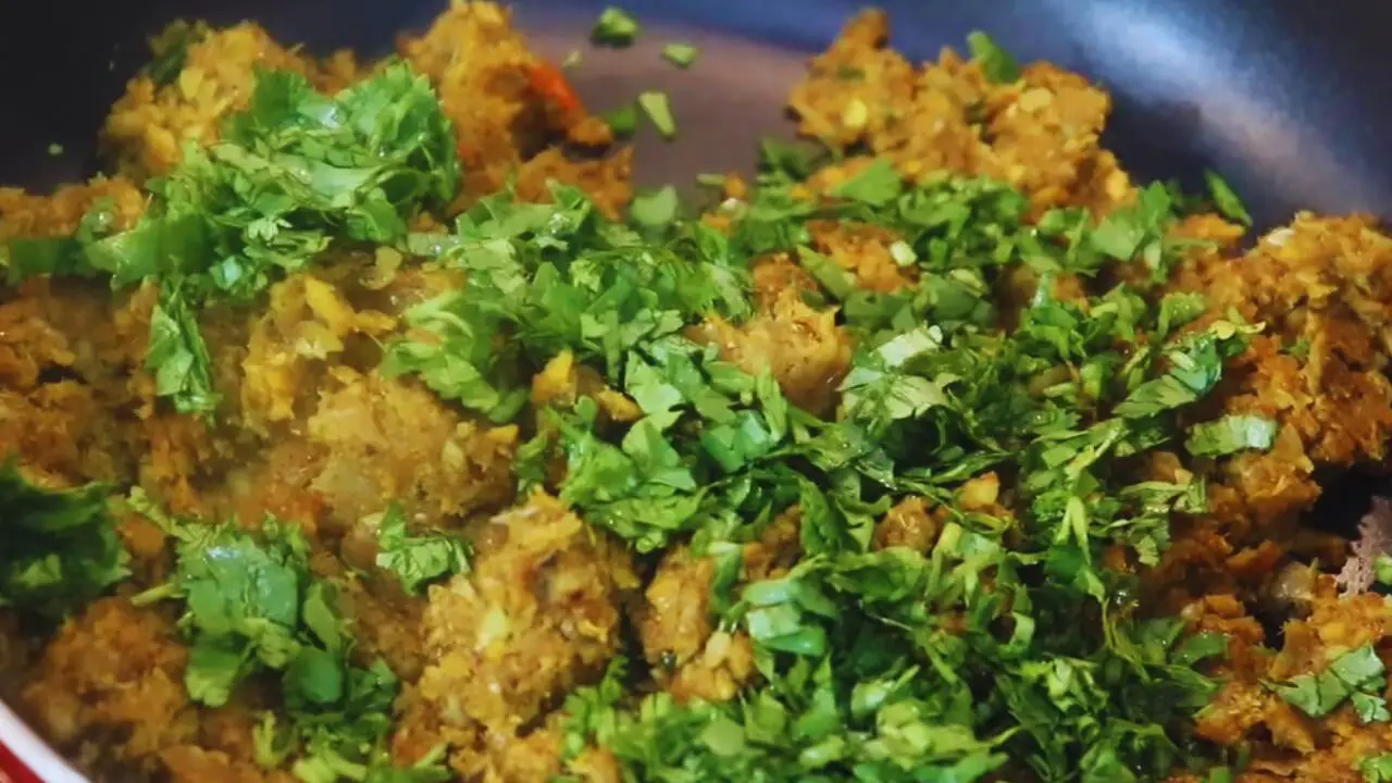 Adding coriander leaves to Fish Chop ingredients 