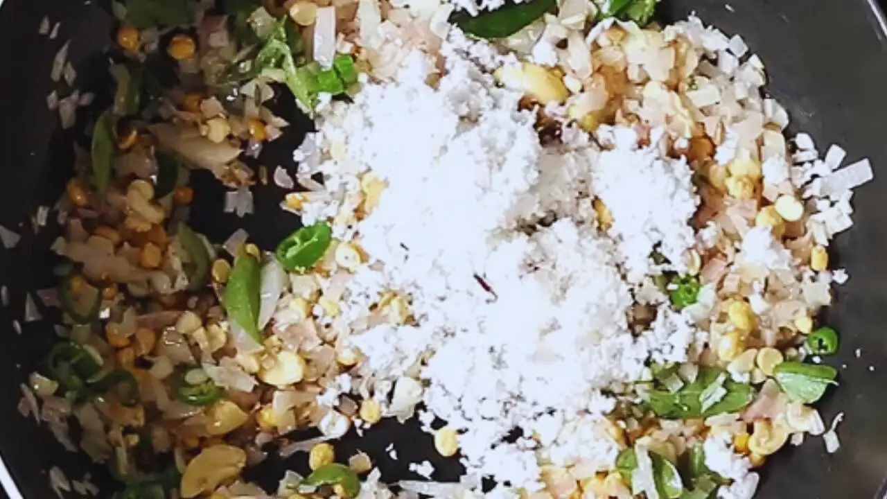 Adding curry leaves and coconut