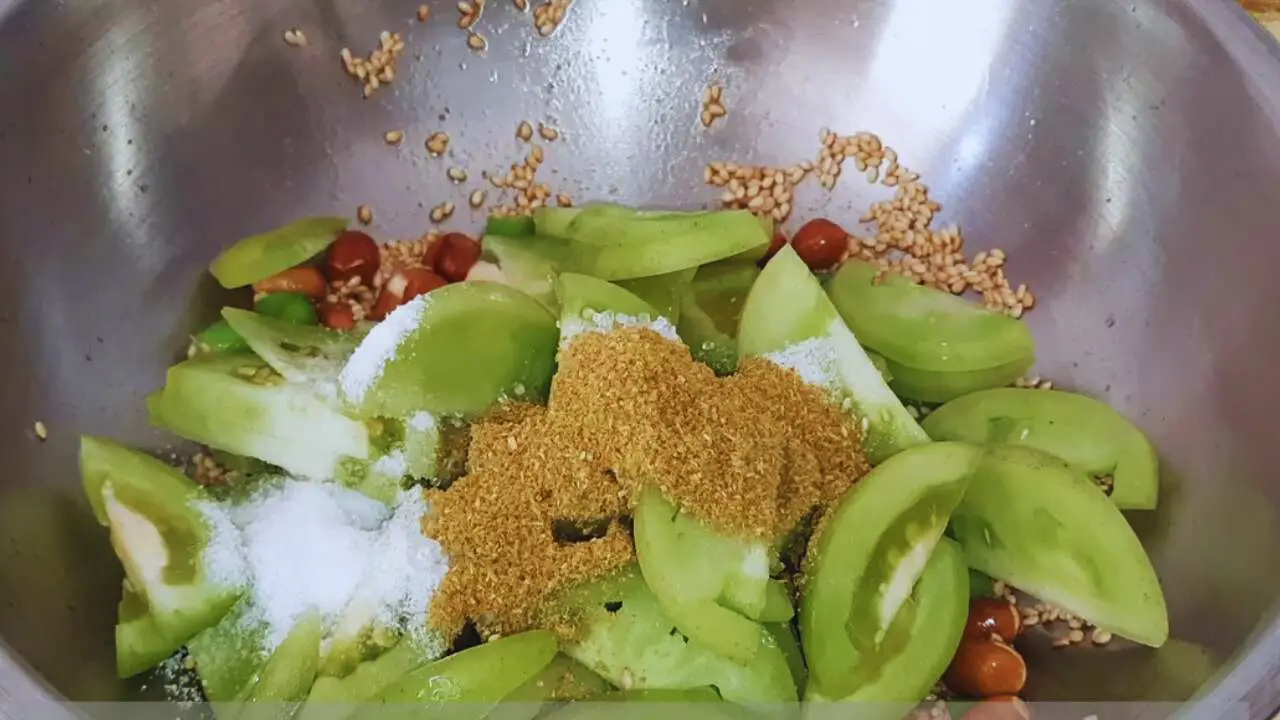 Adding green tomatoes and spices 