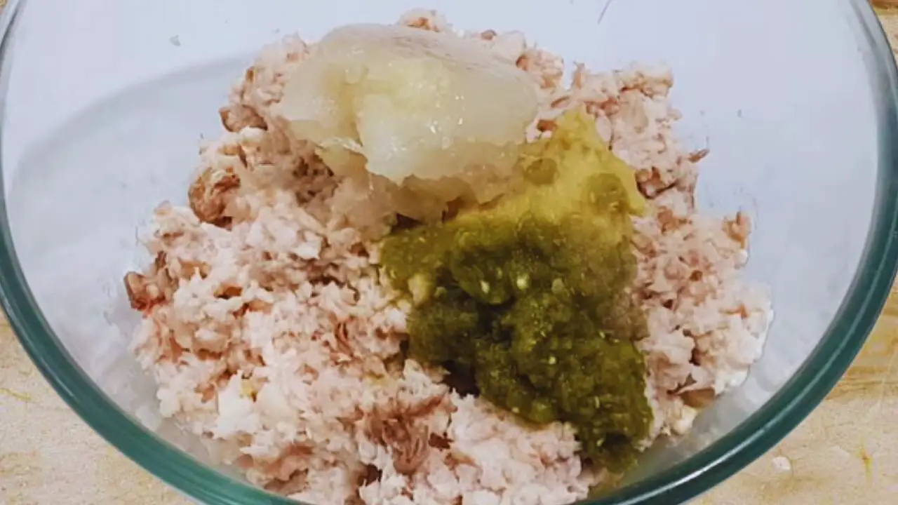 Adding onion and ginger garlic paste to fish 