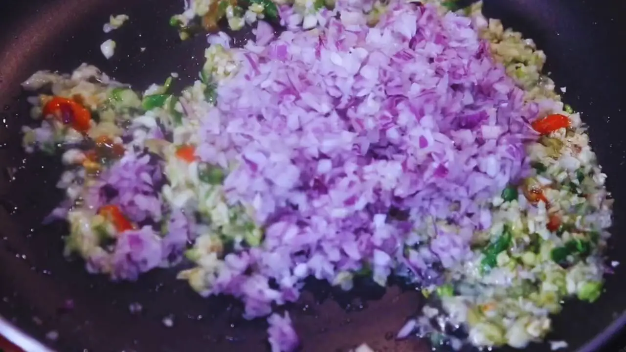 Adding onions to the spices to make Fish Chops