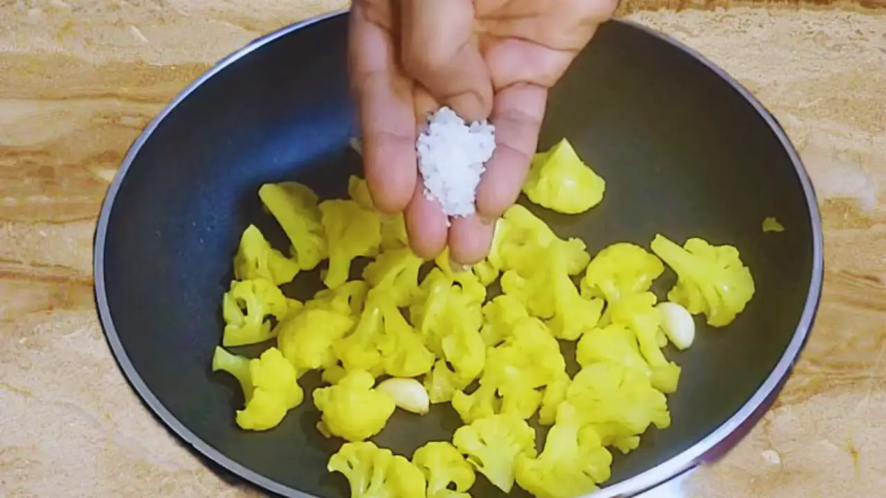 Adding parboiled cauliflower and salt