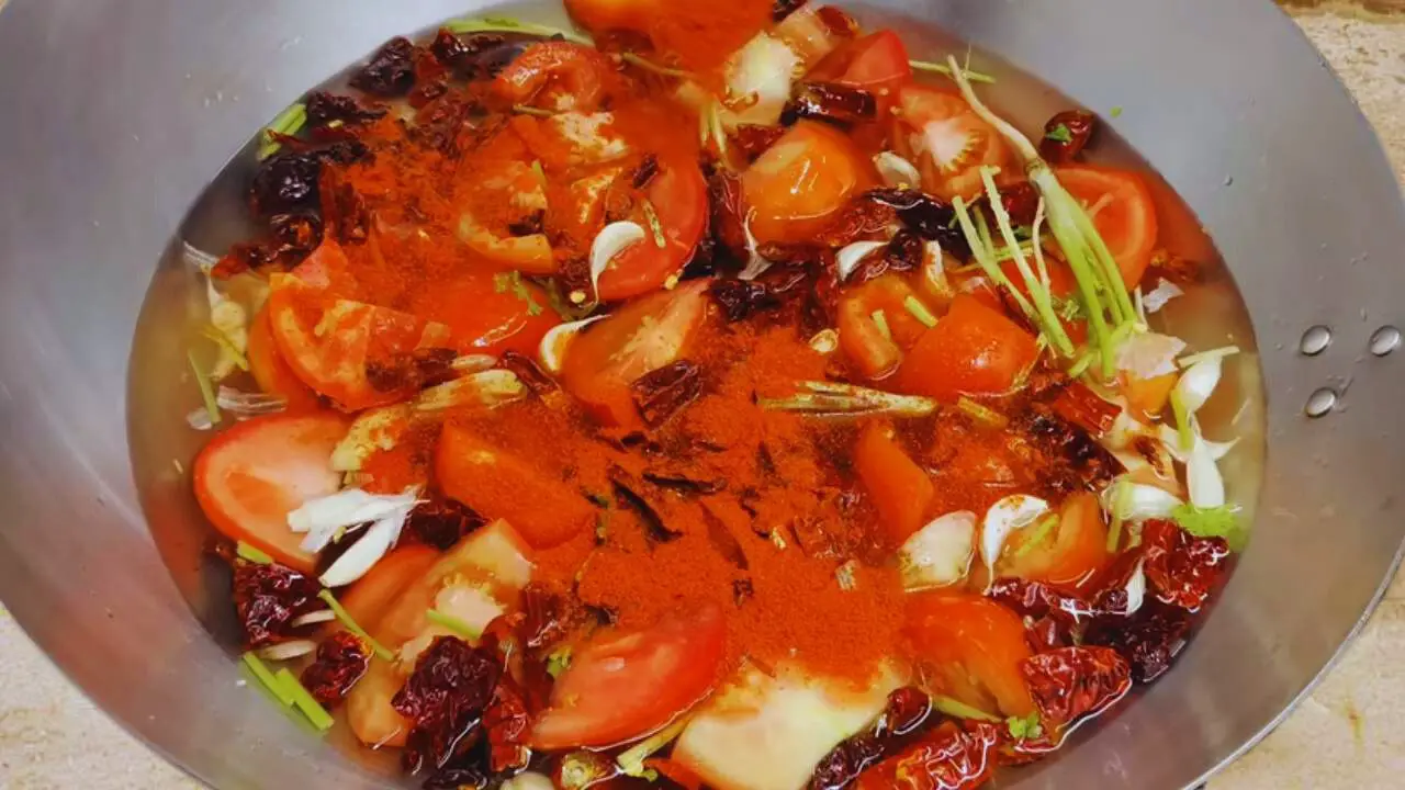 Adding red chili powder to the ingredients of Momos Chutney 