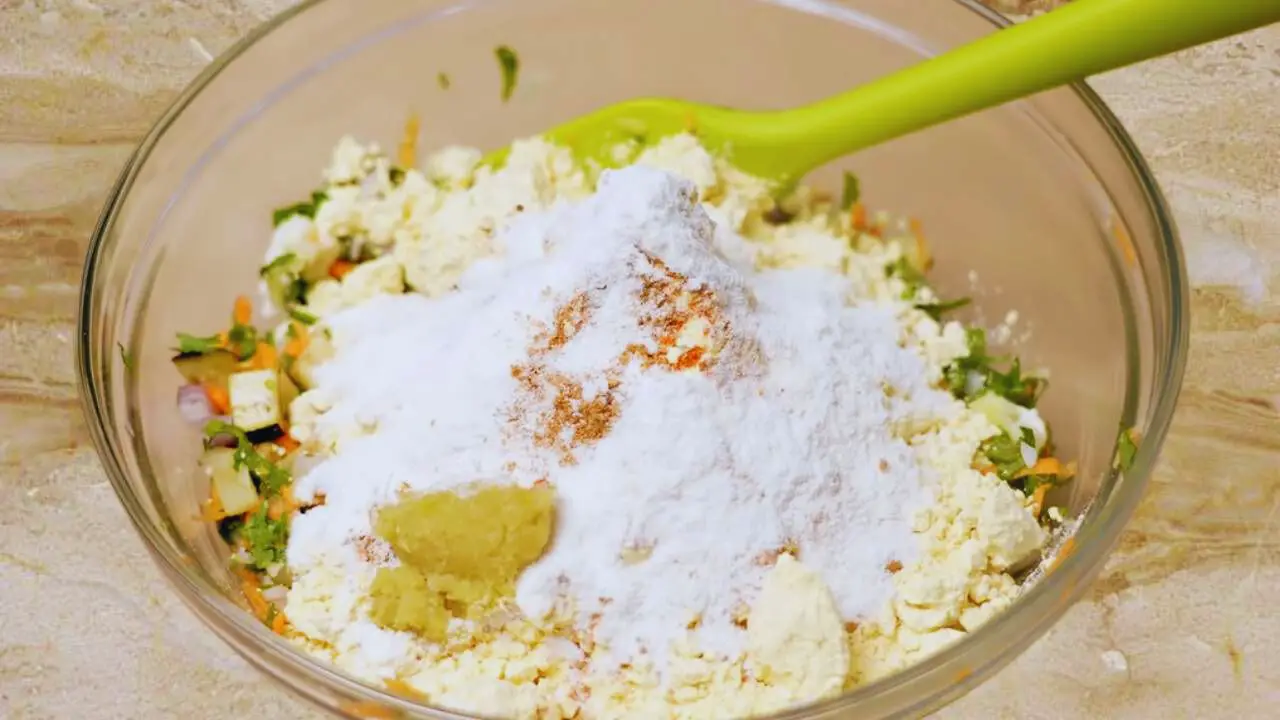Adding rice flour and ginger garlic paste to Vegetable Pakora mixture