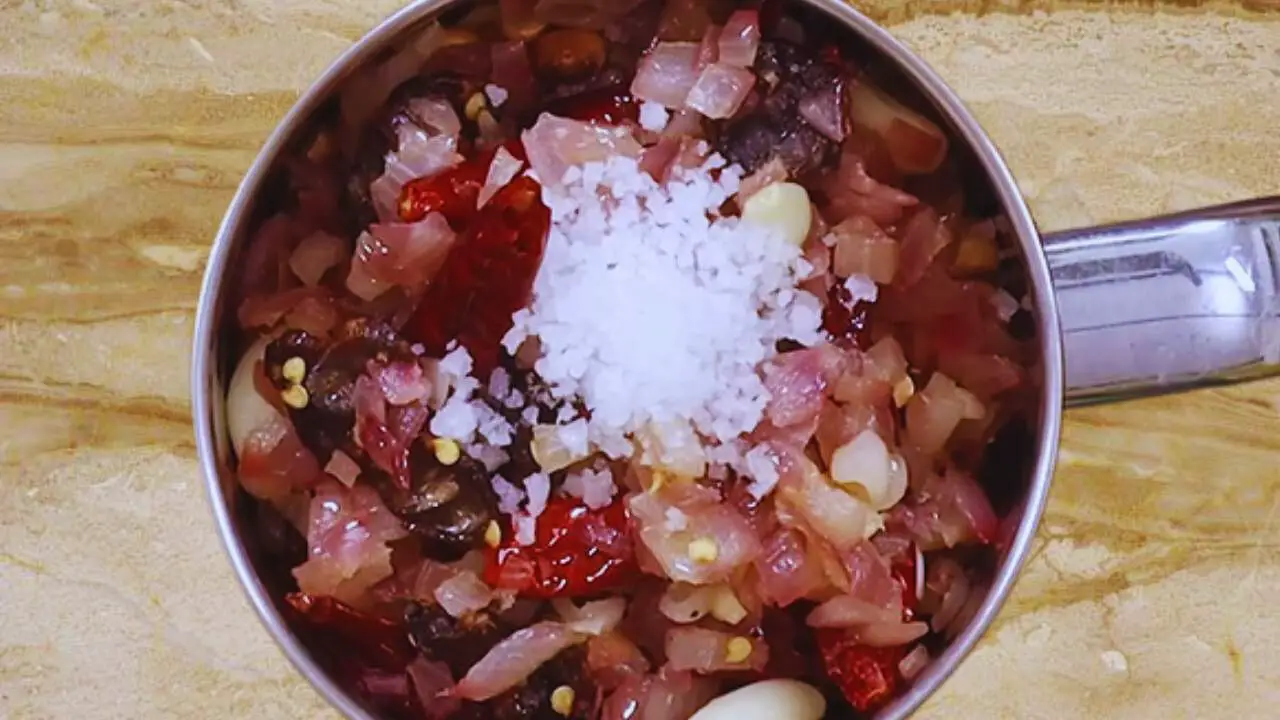 Adding rock salt to peanut chutney ingredients 