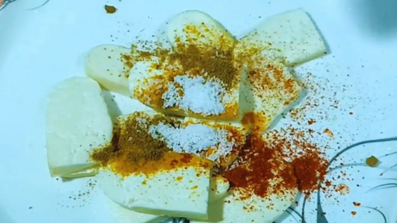 Adding spice powder to paneer slices to make pakoras 