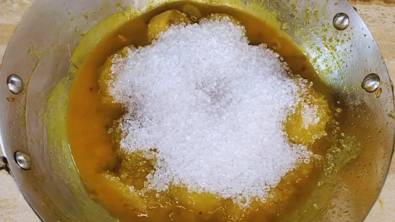 Adding sugar to Hog Plum Chutney 