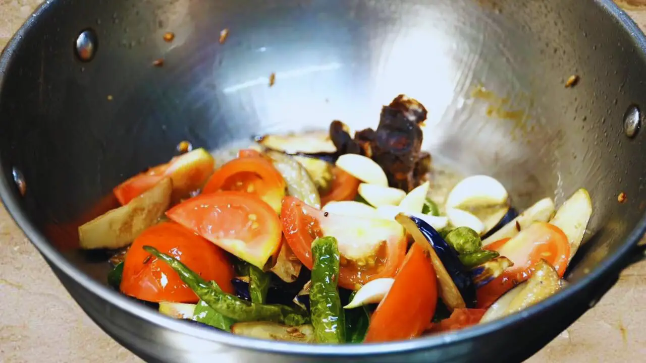 Adding tamarind and garlic to Brinjal Chutney ingredients 
