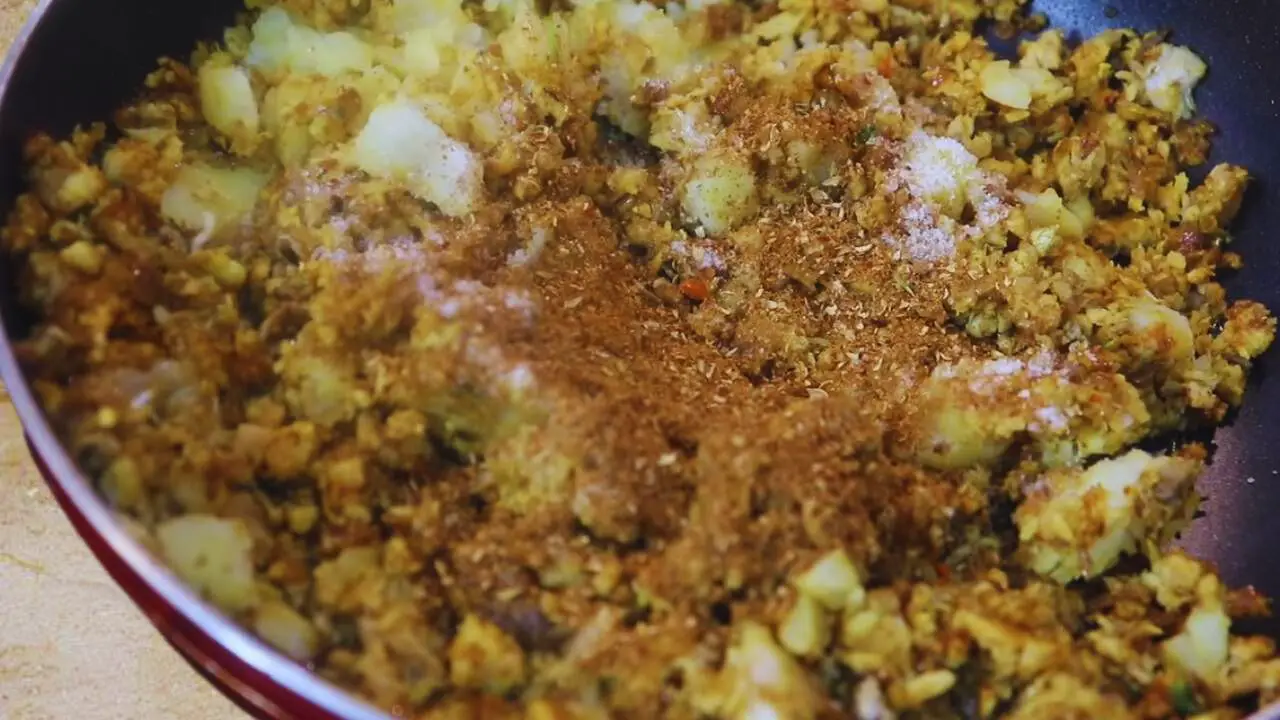 Adding the roasted and ground spice powder to Fish Chop ingredients 