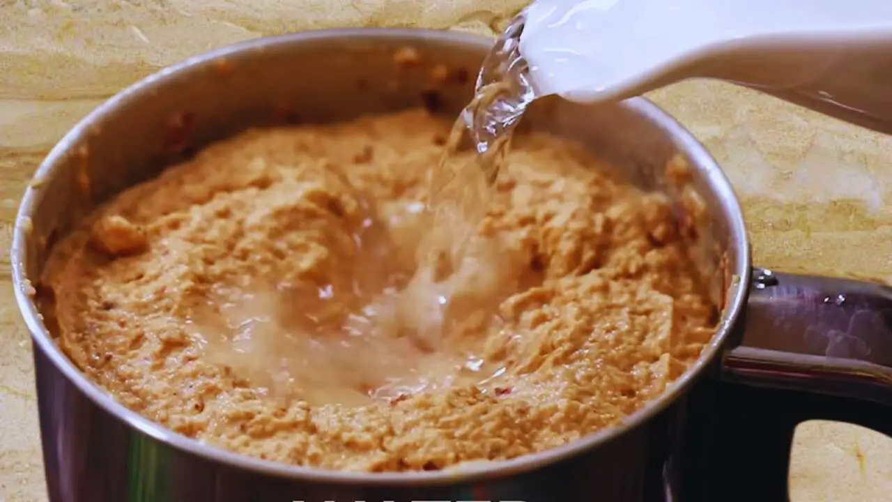 Adding water to peanut chutney paste 