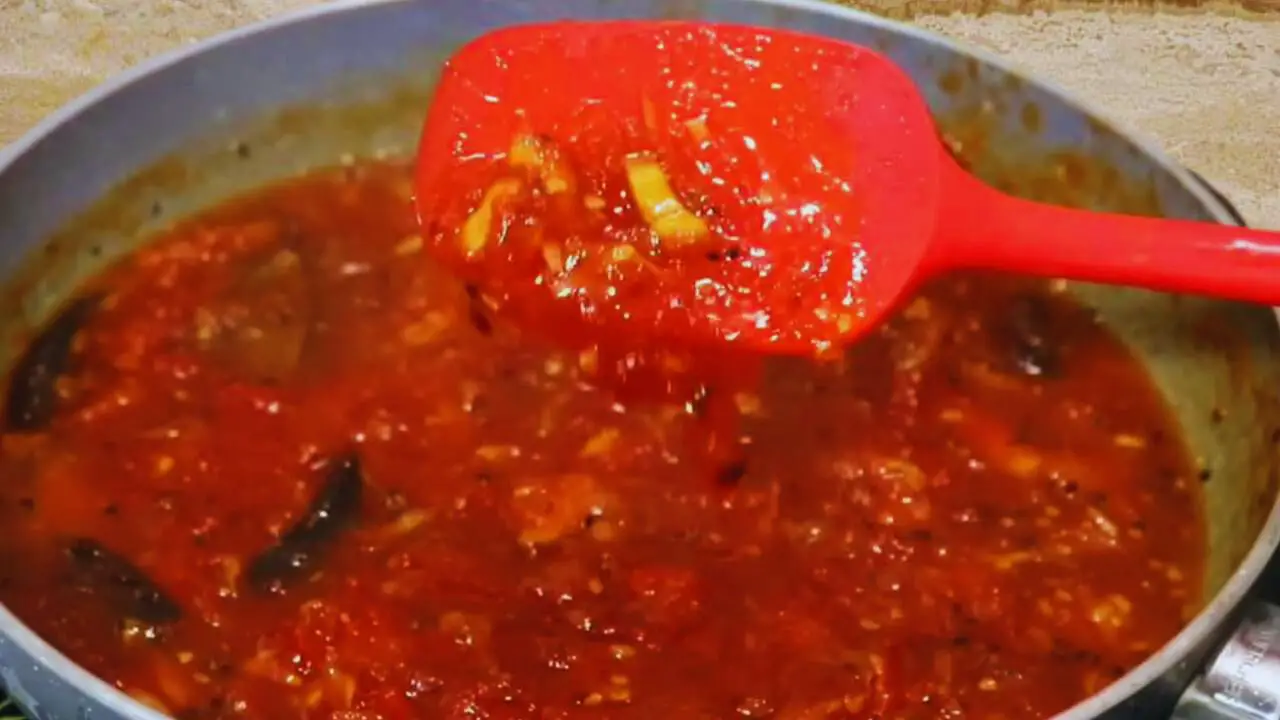 Checking texture of tomato chutney