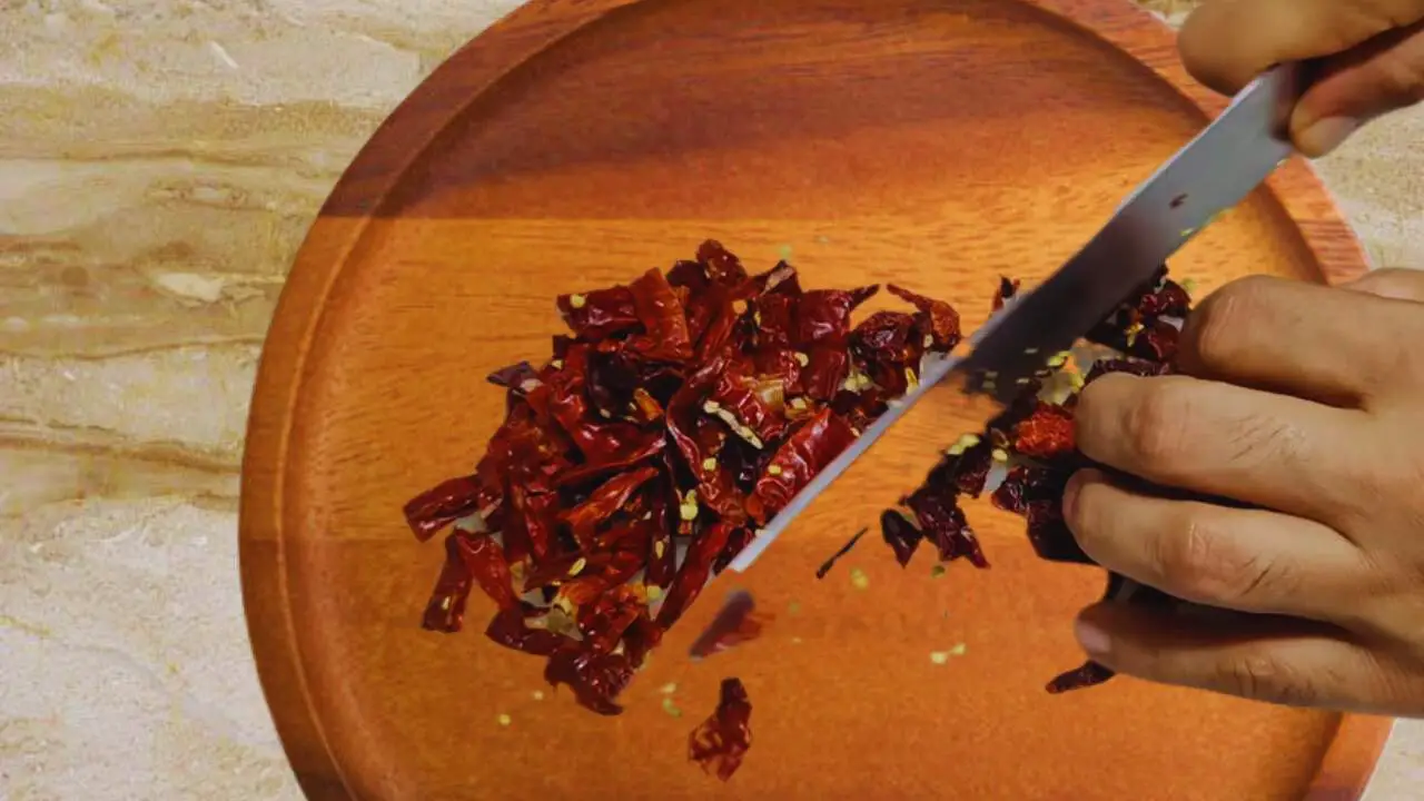 Cutting dry chilies to make Momos Chutney 