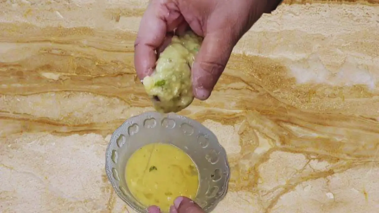 Dipping prawn kabab in egg wash 