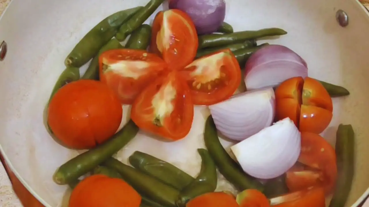 Tomato green chili chutney recipe step 5 Frying tomatoes and onions to make Tomato Green Chili Chutney