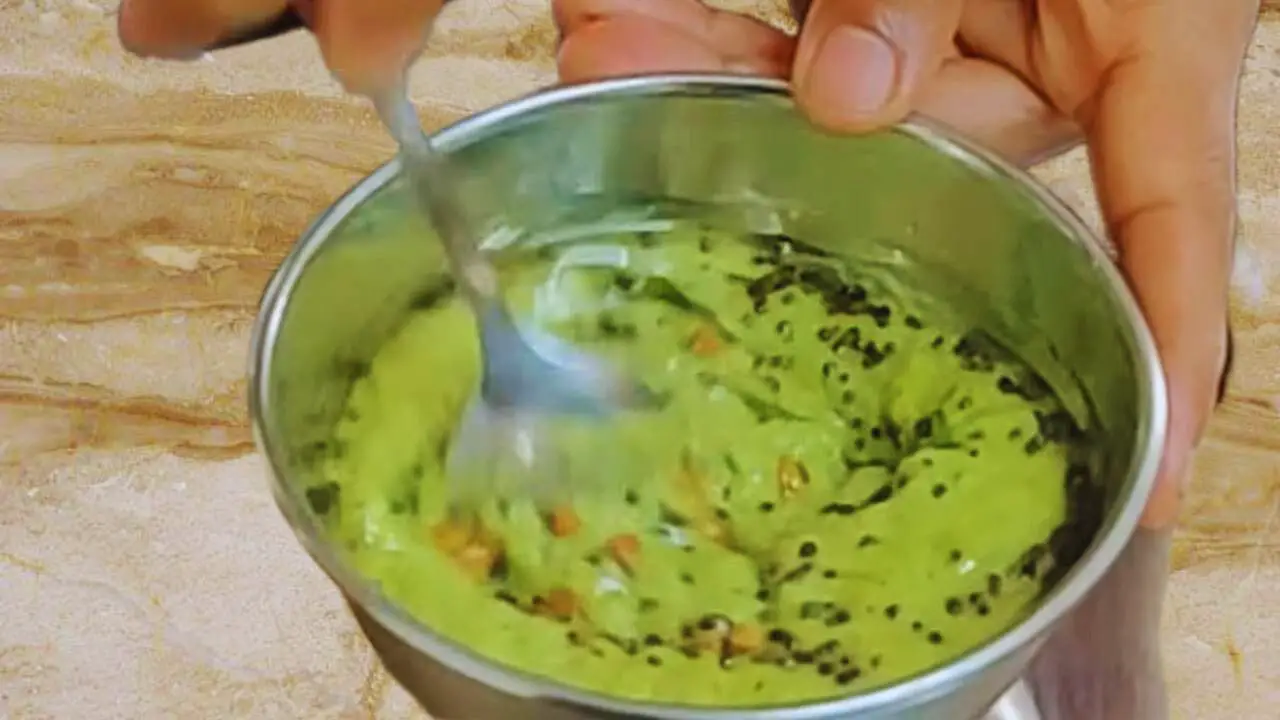 Mixing tadka with Capsicum Chutney paste 