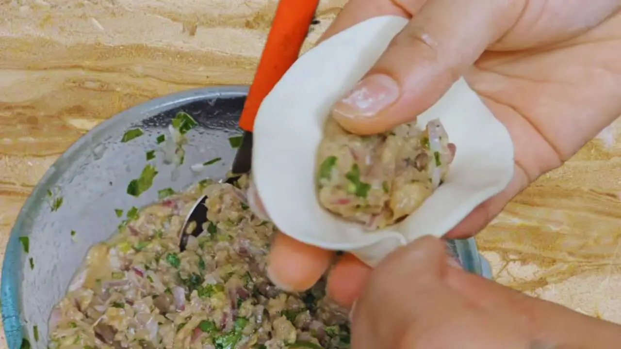 Placing the Fish Momo stuffing 