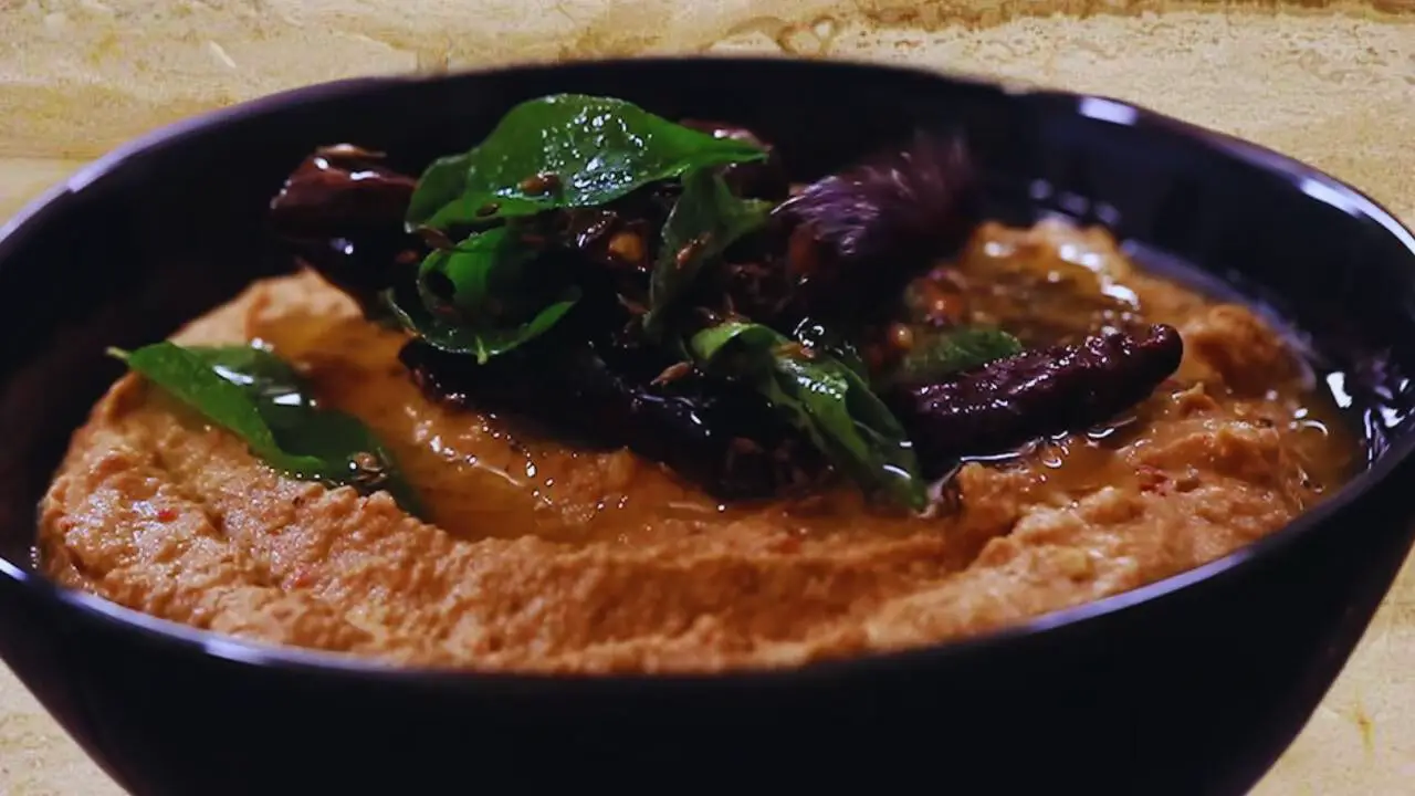 Pouring half of the tadka to the peanut chutney paste 