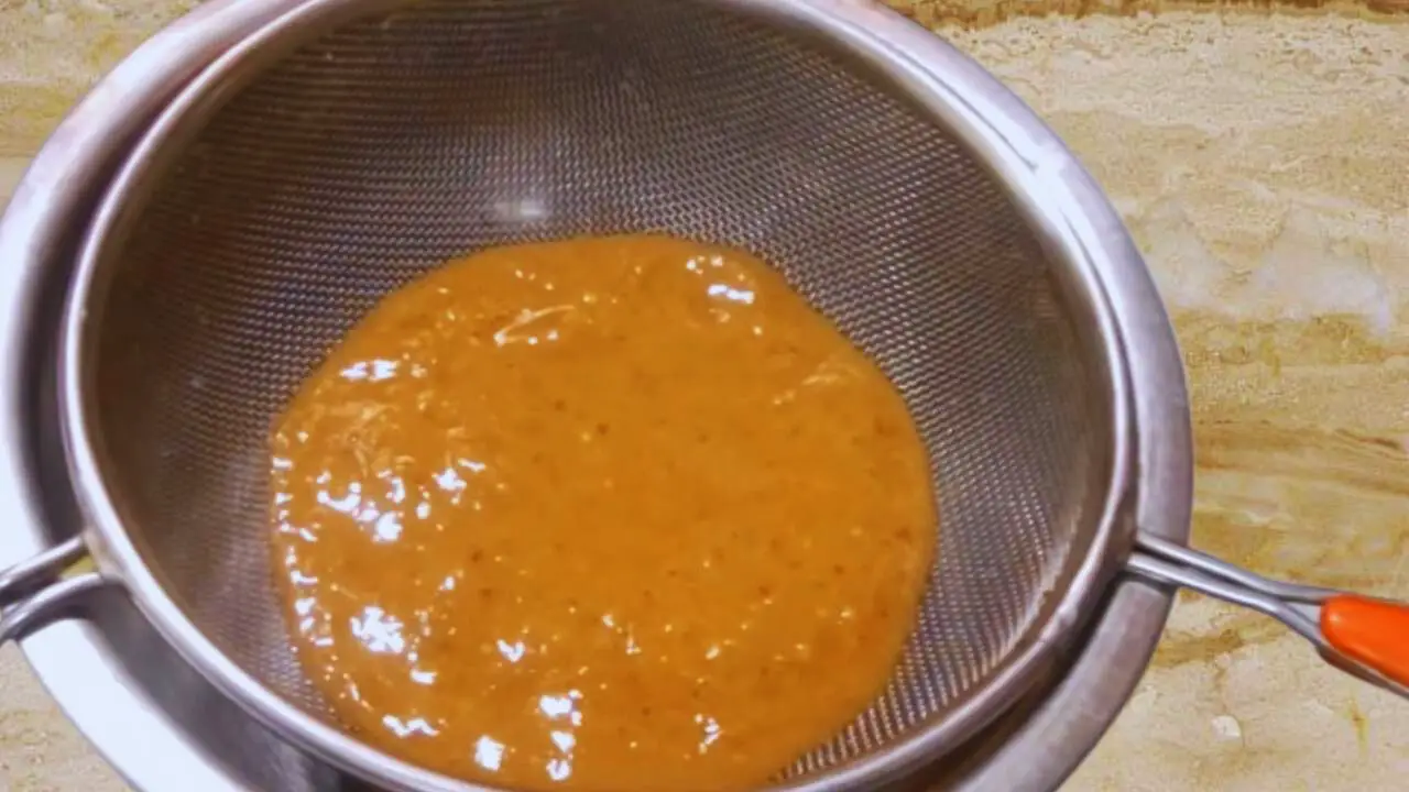 Pouring tamarind chutney paste to the strainer 