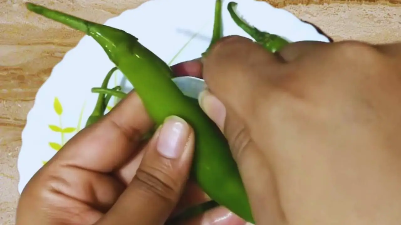Slitting chilies to make pakoras