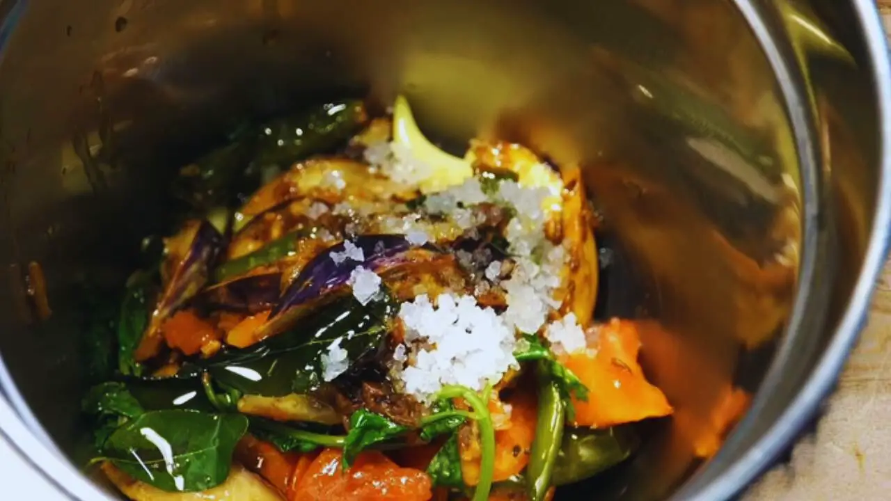 Transferring Brinjal Chutney ingredients to a grinder 