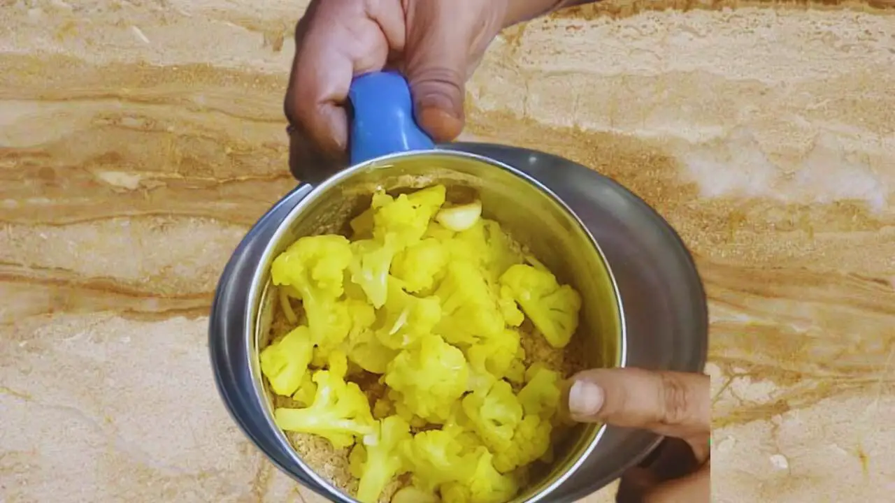 Transferring cooked cauliflower to a grinder 