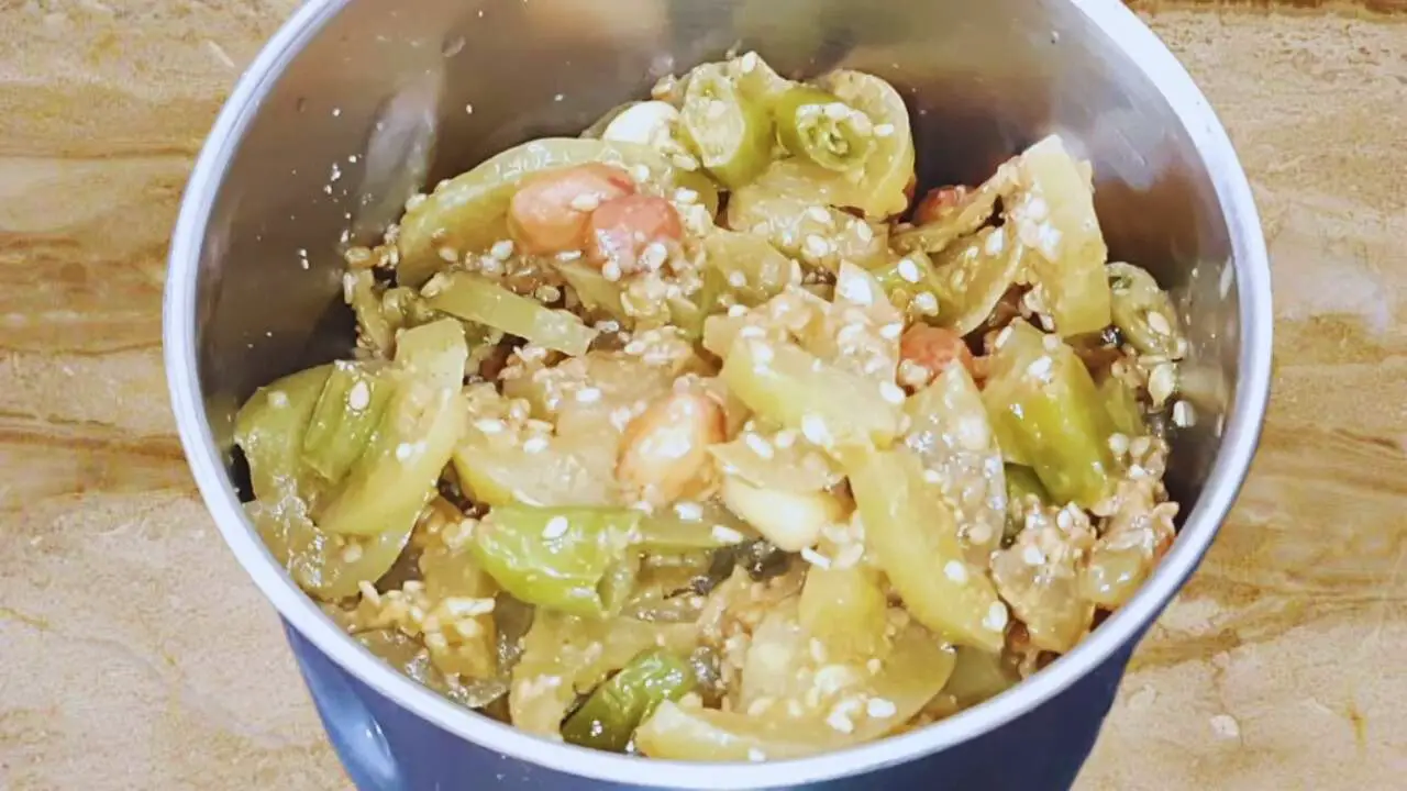 Transferring Green Tomato Chutney ingredients to a grinder 