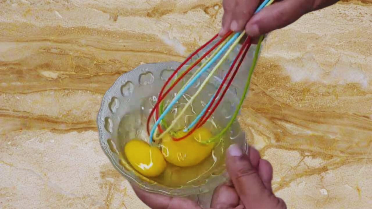 Whisking eggs to make prawn kababs