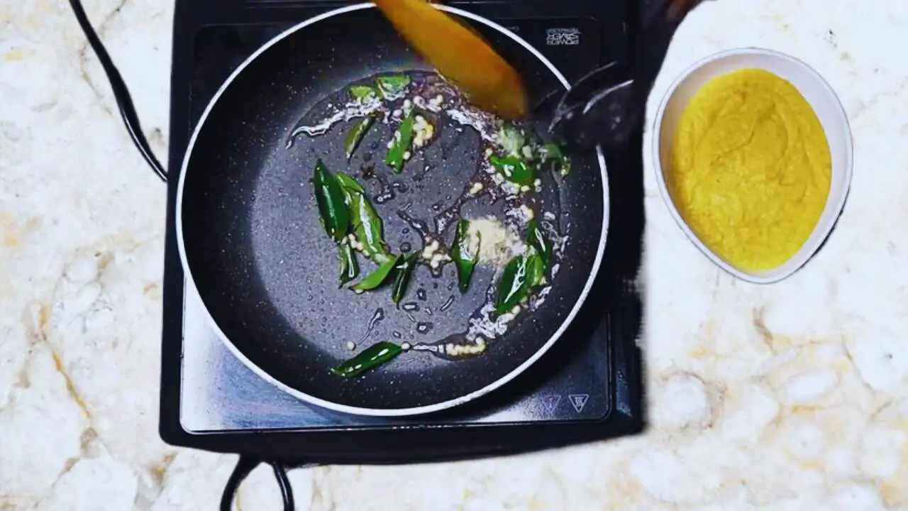 Adding asafetida to the tadka for Sweetcorn Chutney 