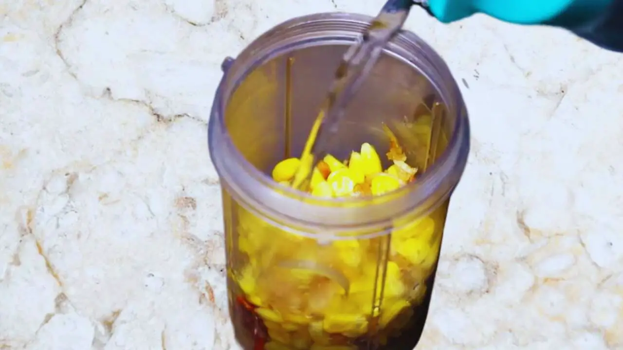 Transferring sweetcorn mixture to grinder 