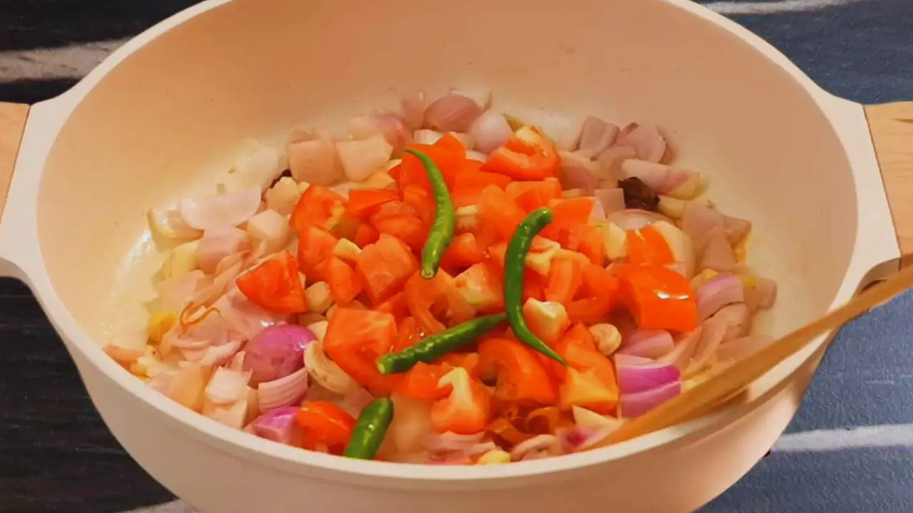 Adding tomatoes, chilies, and other ingredients 