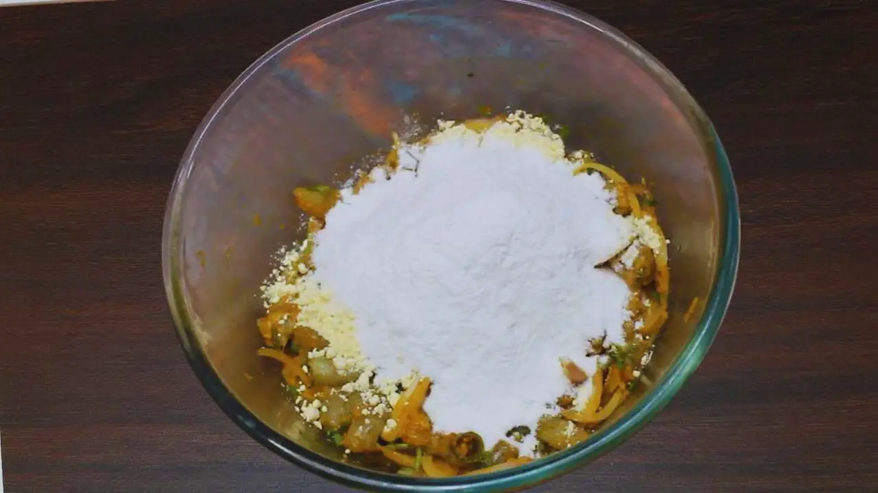 Adding rice flour and besan to prawn pakora mixture 