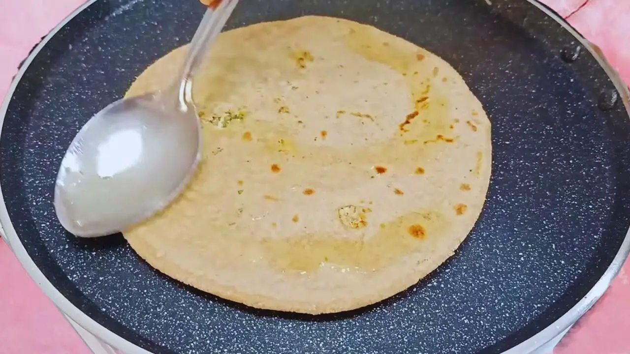 Paneer paratha recipe step 9 Applying ghee on paneer paratha