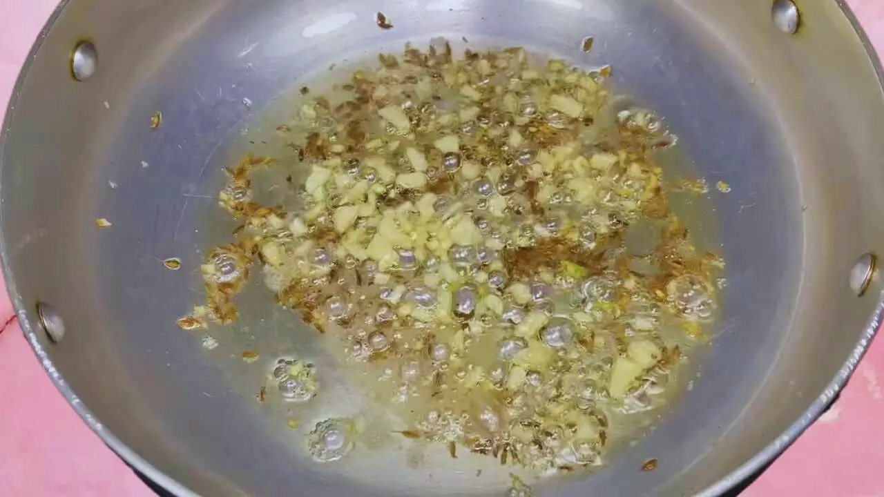 Aloo palak recipe step 2 Frying cumin seeds and garlic